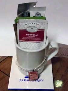 My last minute Teacher's Birthday Gift.  Long story of why but it was delivered this morning.  A couple years ago I had made but never gave coasters to teachers (my daughter didn't want to go that route) so I did a coaster with the school logo, a cup filled with Hershey's Kisses, Tea and a couple of Starbucks Via Packs and added a necklace.