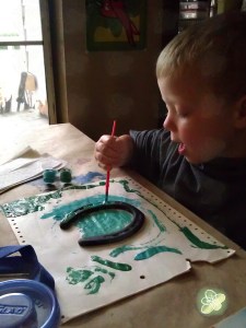 Booga painting a horseshoe. 