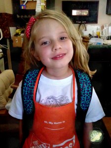 Showing off her backpack in the midst of our home renovations (note the Home Depot Apron).