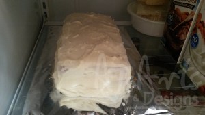 The cake covered in frosting ready for the fondant process.